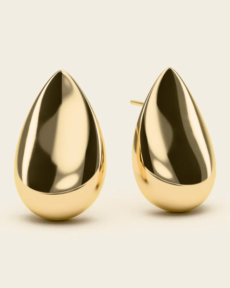 Σκουλαρίκια σταγόνες Αώος: ζευγάρι φουσκωτά, γυαλισμένα σαν καθρέφτης σκουλαρίκια σε σχήμα σταγόνας, με καρφάκι, σε ασήμι 925 επιχρυσωμένο, σε φόντο ιβουάρ.
