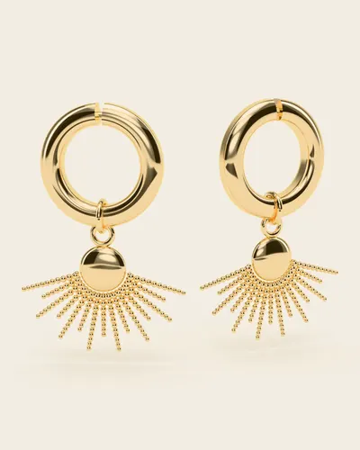 Ilios Sunburst Huggies: a pair of small huggie hoops, each with a sunburst charm of a half-round hub and fine beaded rays fanning out below it, in gold-plated 925 silver, on an ivory background.